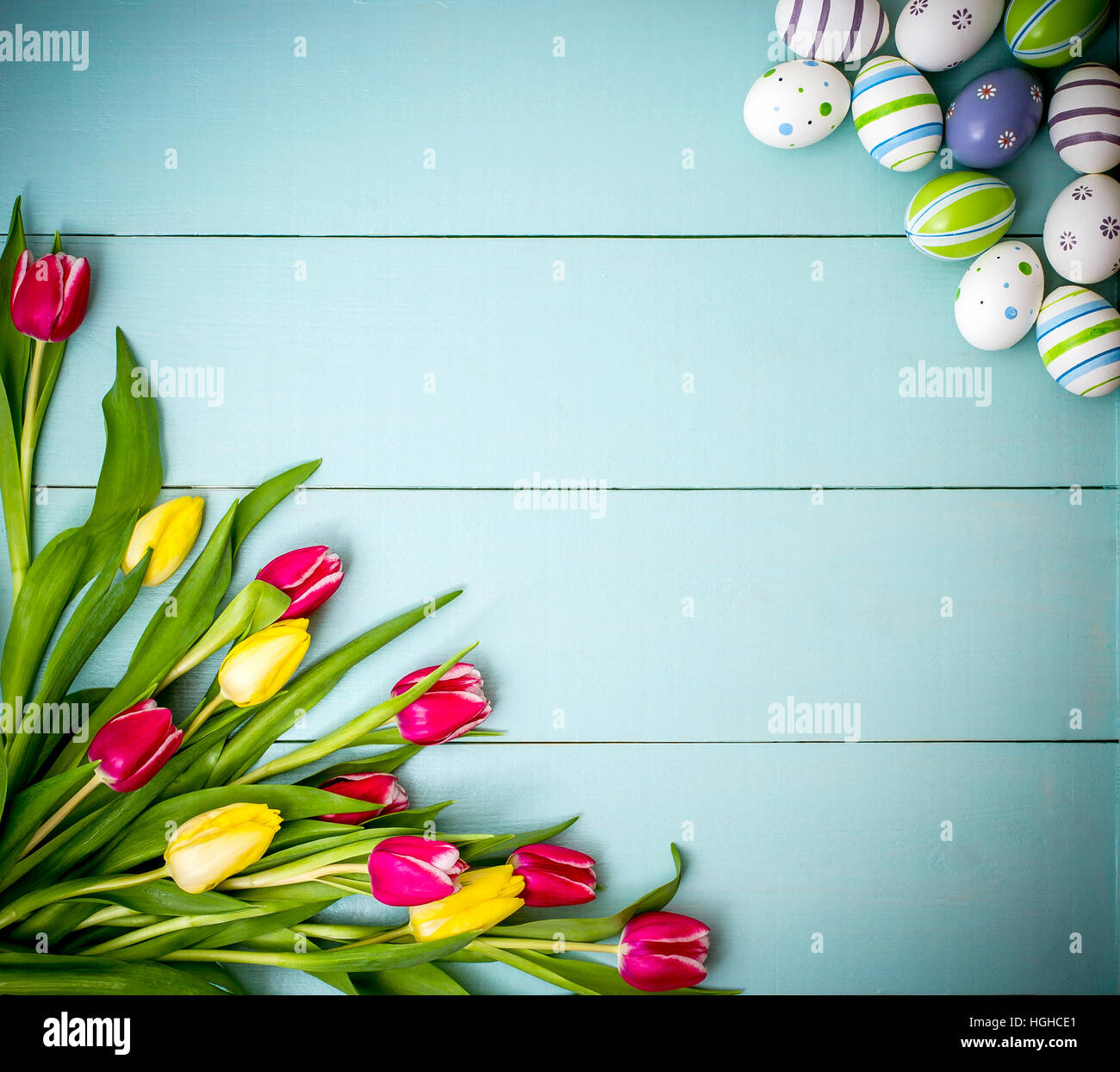 Rosso e tulipani gialli con colorate uova di Pasqua Foto Stock