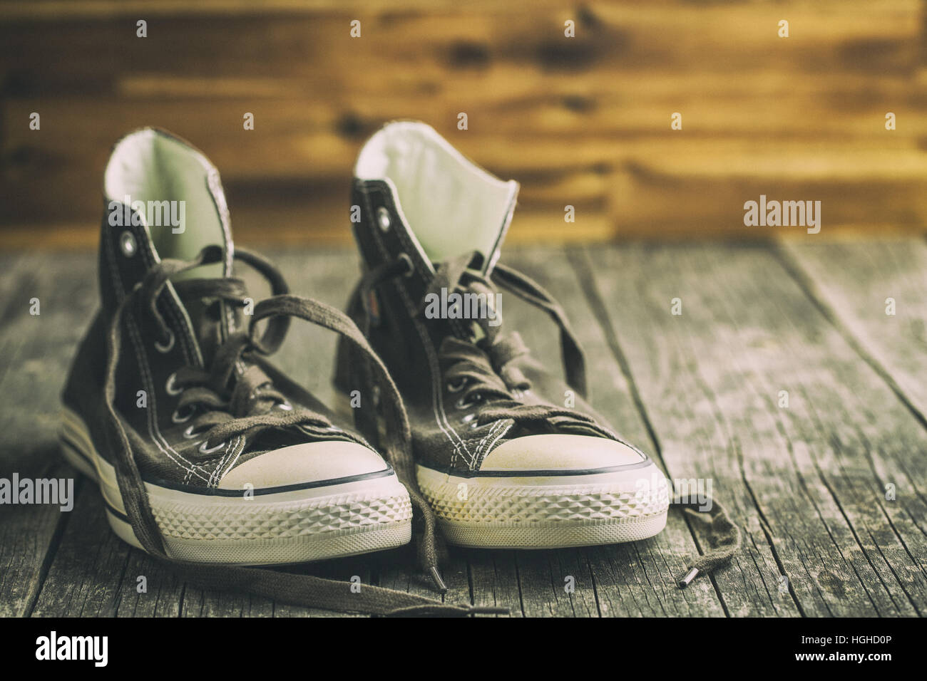 Il vintage sneakers prima parete in legno. Retrò scarpe da tennis. Foto Stock