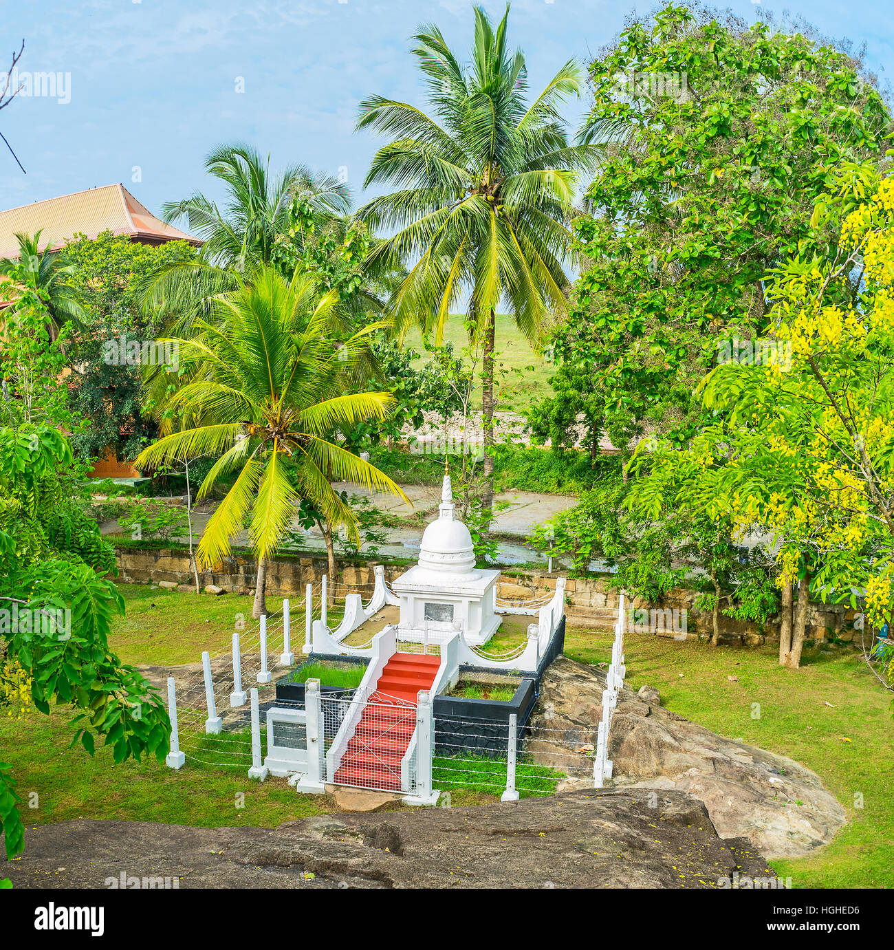 Il bianco stupa buddisti è nascosto nel lussureggiante giardino del tempio Isurumuniya, Anuradhapura, Sri Lanka. Foto Stock