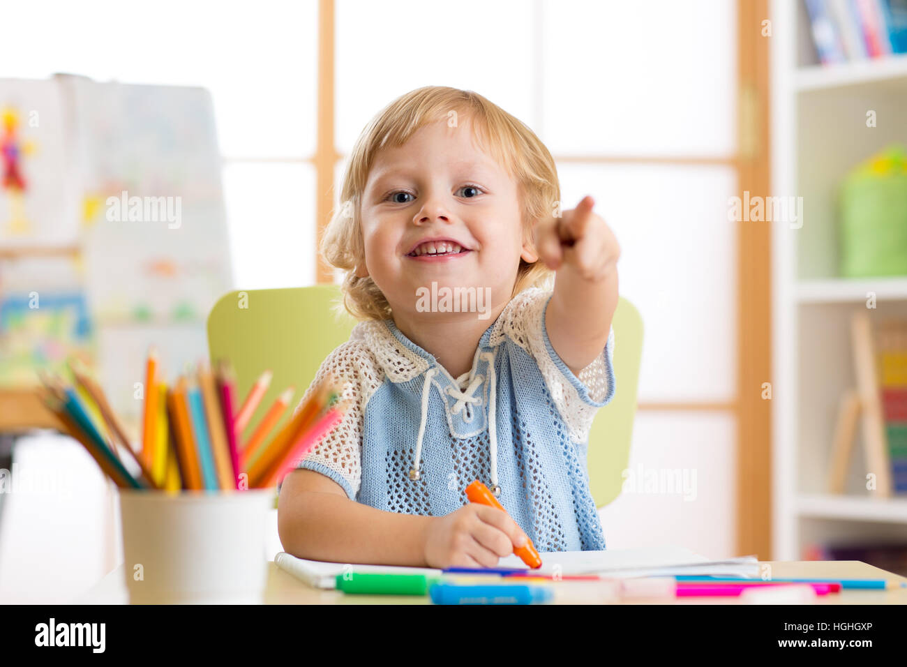 Carino bambino piccolo ragazzo di disegno con pennarello in aula kindergarten Foto Stock