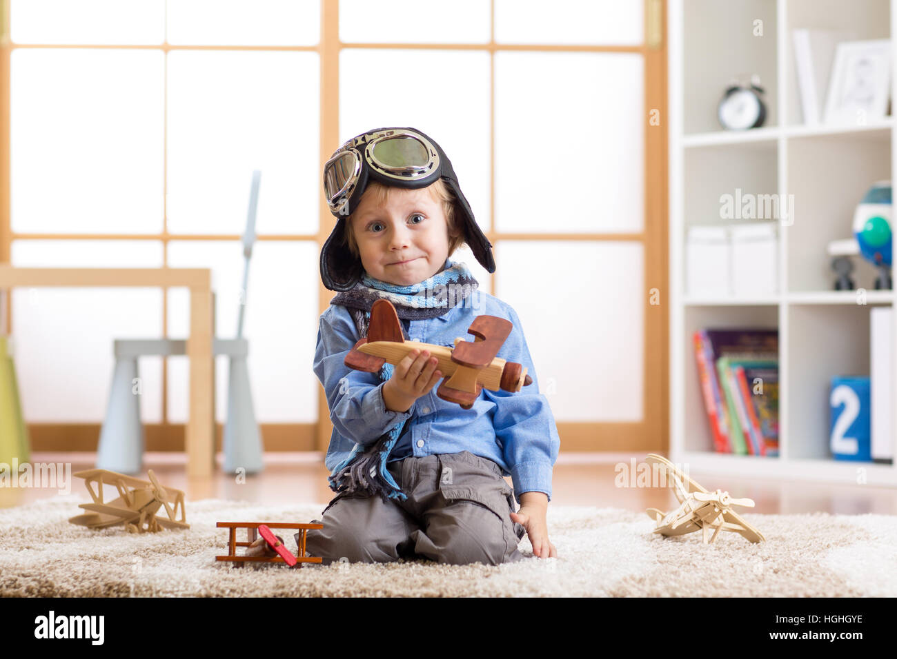 Funny kid giocando con gli aeroplani giocattolo a casa. Viaggi e concetto di sogno Foto Stock