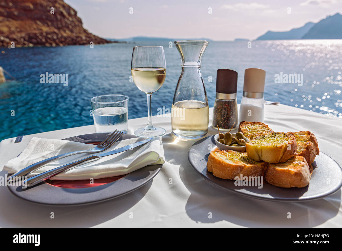 La tabella con il cibo e il vino sullo sfondo del mare Foto Stock
