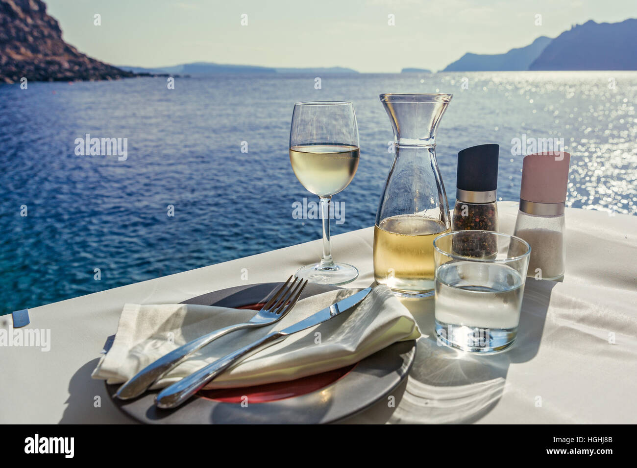 La tabella con il cibo e il vino sullo sfondo del mare Foto Stock