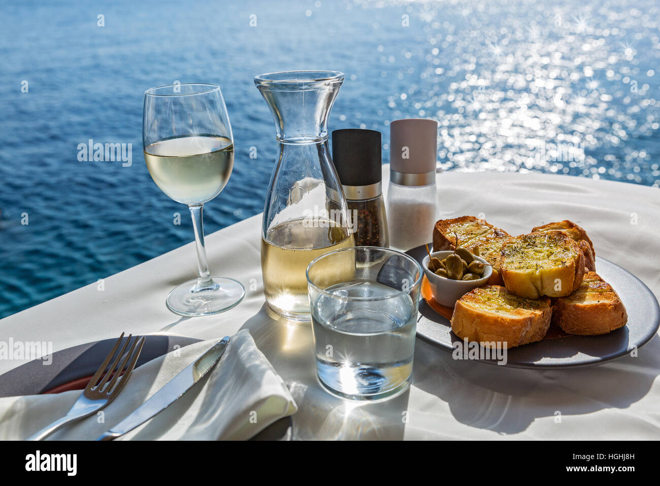 La tabella con il cibo e il vino sullo sfondo del mare Foto Stock