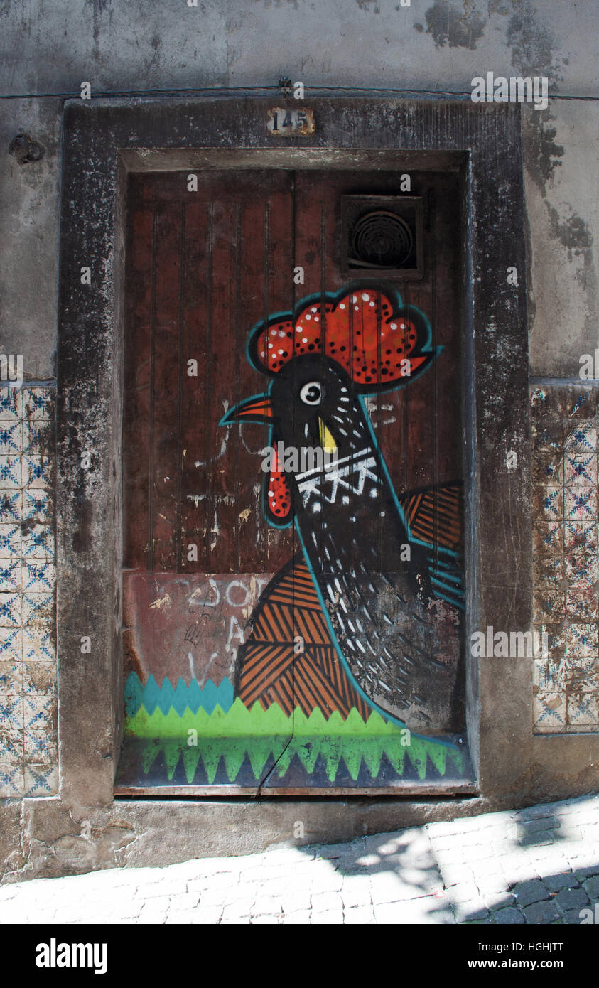 Porto: dettagli di vicoli della città vecchia con vista di una porta di legno decorato con il gallo di Barcelos, uno dei simboli del Portogallo Foto Stock