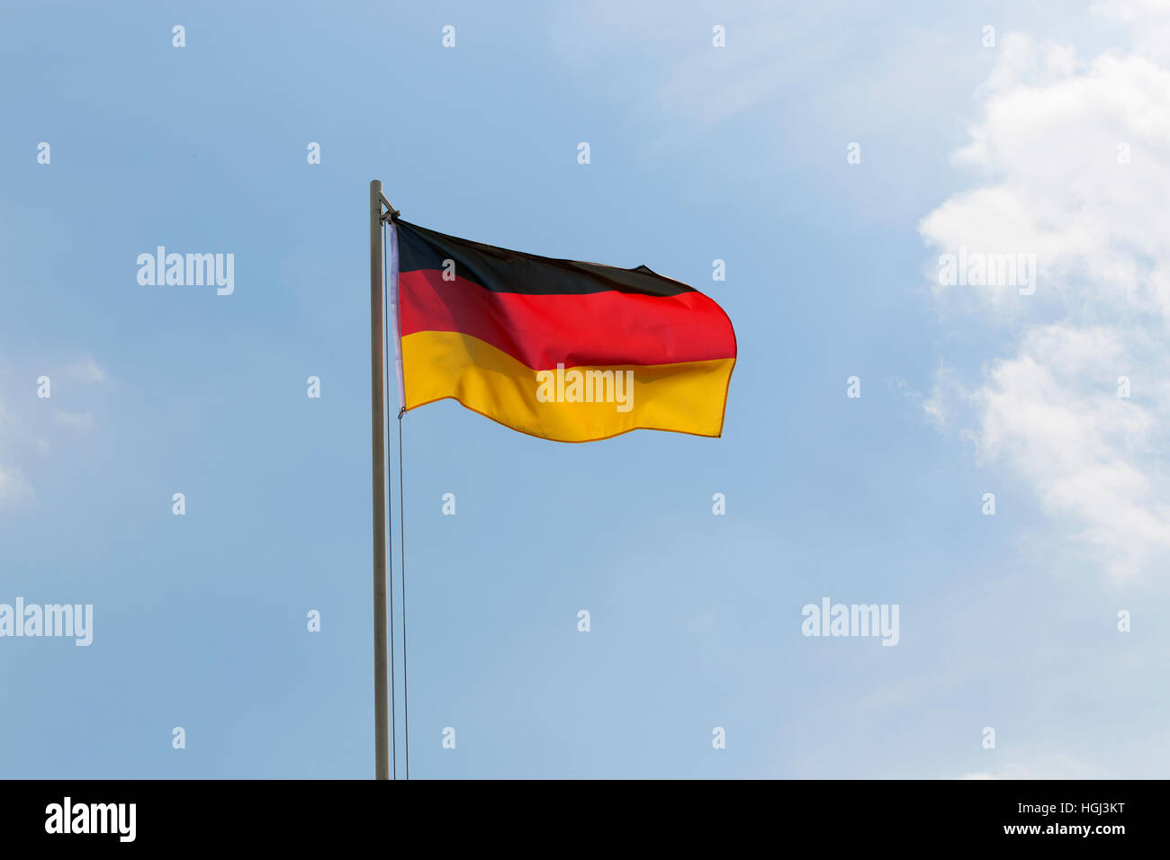 Bandiera nazionale della Germania su un pennone di fronte blu cielo Foto Stock