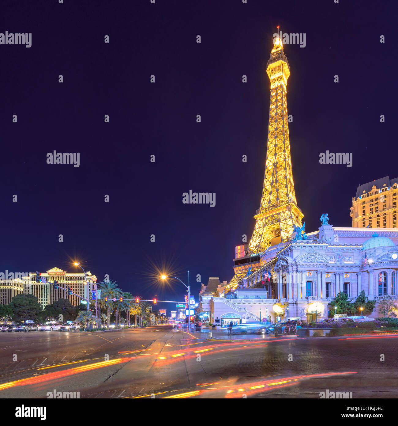 Las Vegas Strip con il traffico in movimento e l'Hotel Parigi e la torre Eiffel nel retro. Foto Stock