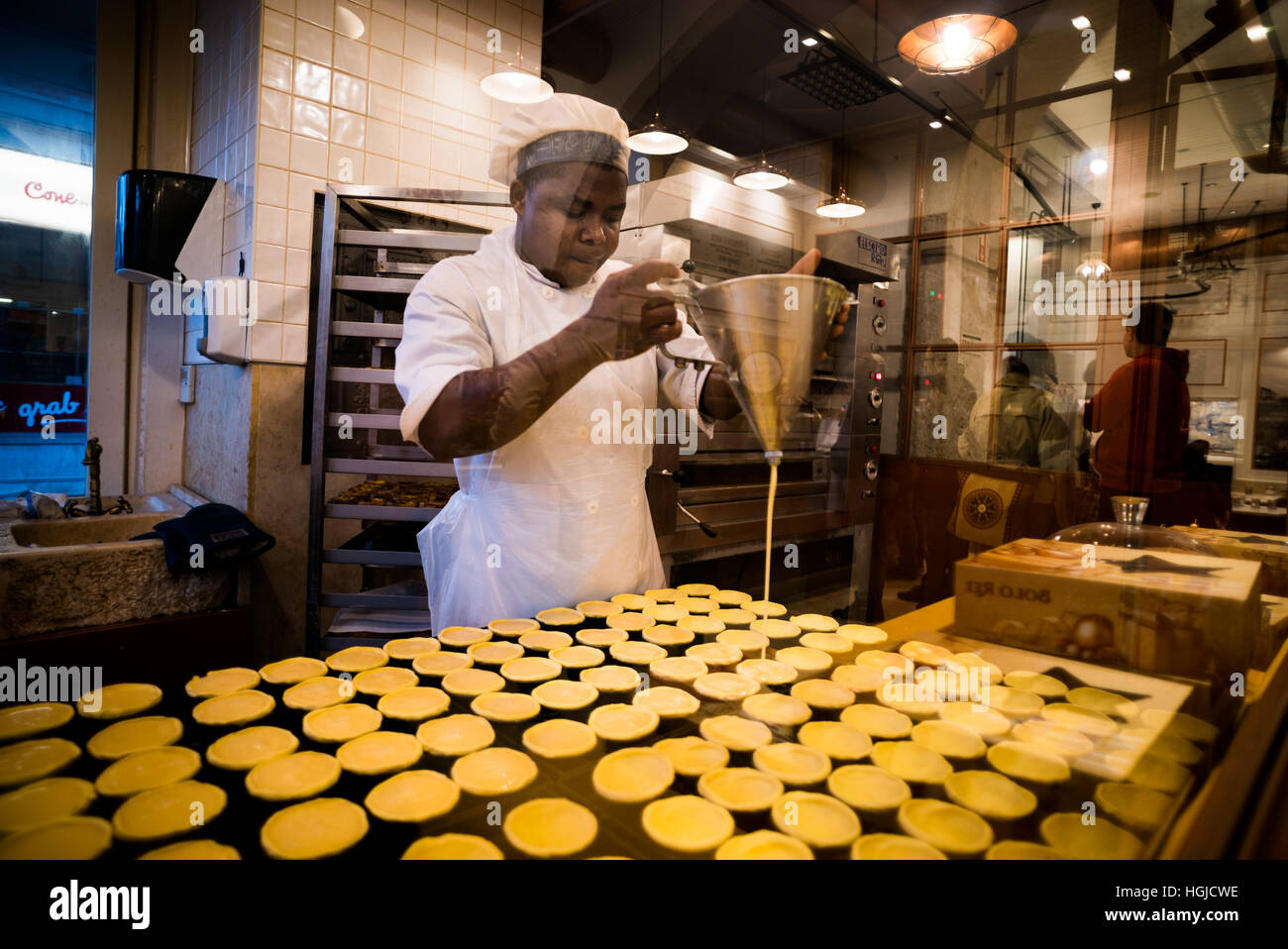 Lo chef prepara il Pastel de nata la pasticceria a Lisbona, Portogallo Foto Stock