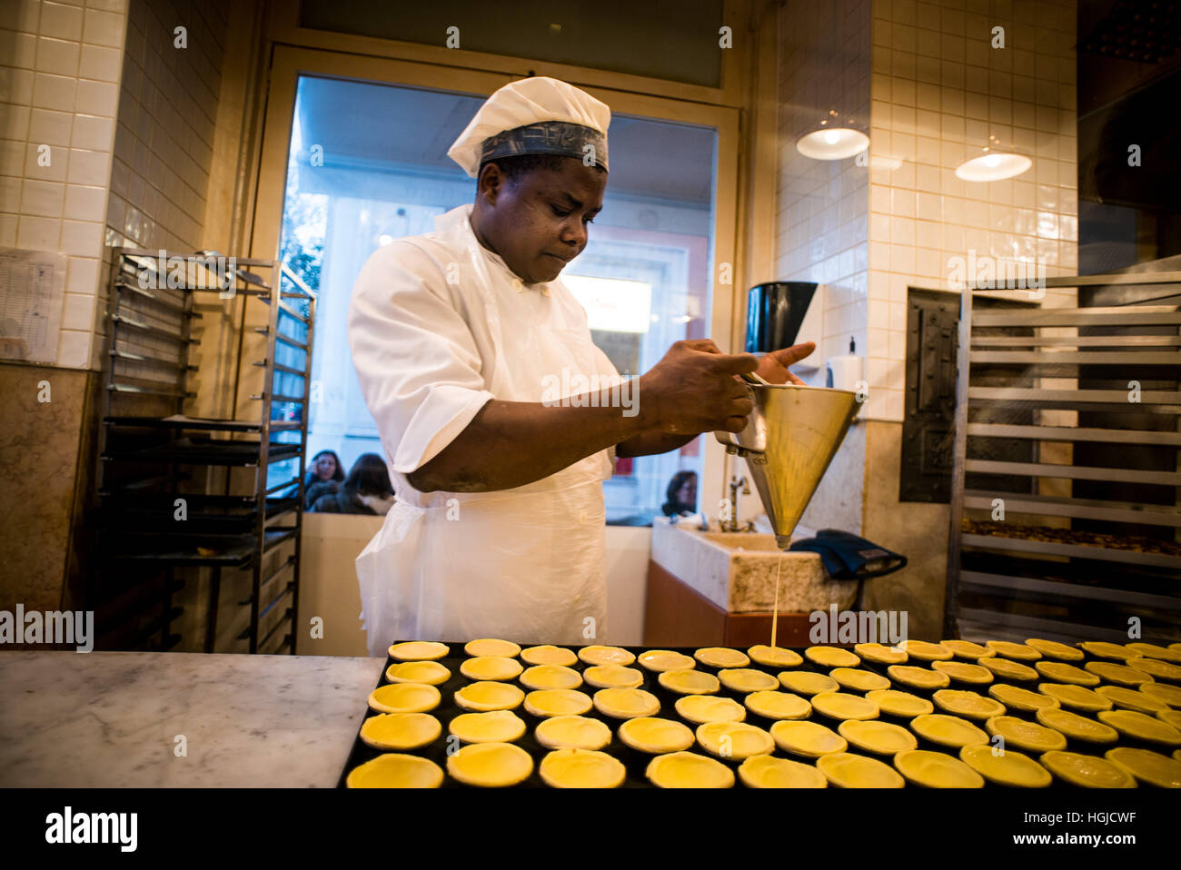 Lo chef prepara il Pastel de nata la pasticceria a Lisbona, Portogallo Foto Stock