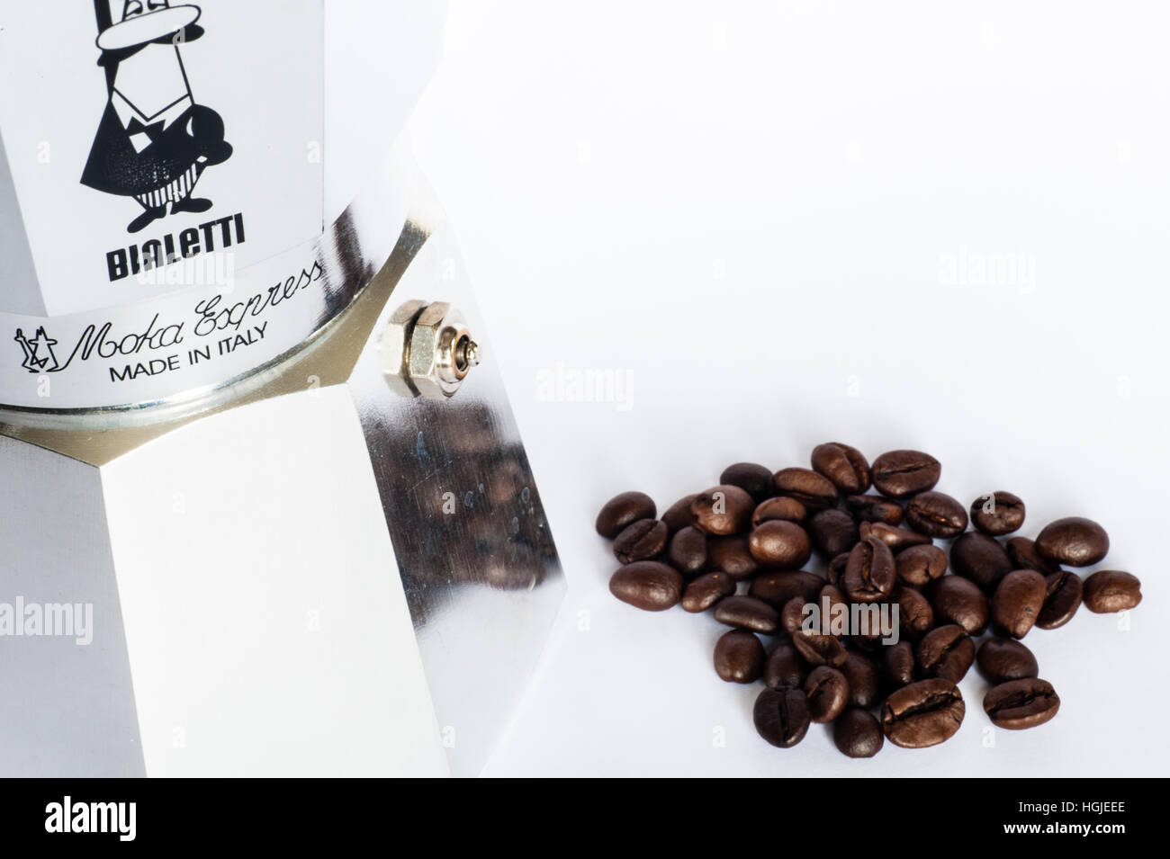Caffettiera Bialetti con chicchi di caffè interi su sfondo bianco con spazio per la copia. Foto Stock