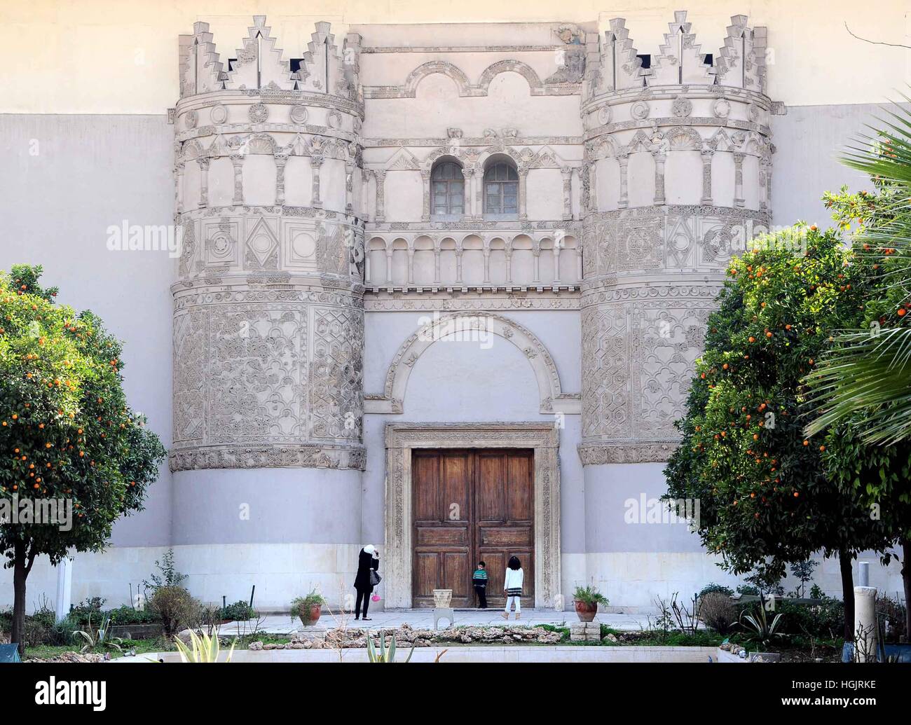 Damasco, Siria. Il 22 gennaio, 2017. Una donna siriana prende una foto dei suoi due bambini di fronte a una replica facciata del castello nel giardino del Museo Nazionale di Damasco, Siria. Lo Stato islamico gruppo ha demolito più preziosi monumenti in Siria le antiche Palmyra, un mese dopo recuperando dalle forze governative del paese, la sua antichità chief detto venerdì. Le Nazioni Unite Venerdì portato condanna di questi attacchi, chiamando la distruzione di un "crimine di guerra " e " Pulizia culturale". Credito: Ammar Safarjalani/Xinhua/Alamy Live News Foto Stock