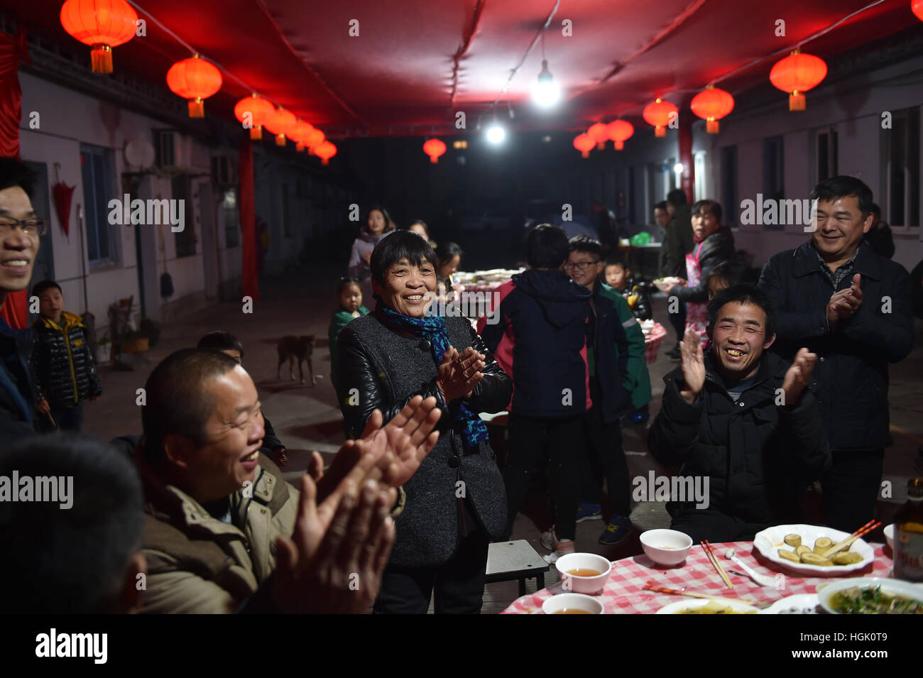 Ningbo Ningbo città di East cinese della Provincia di Zhejiang. 23 gen 2017. Wu Changlan (3 L), commerciante di rottame canta durante la cena di una comunità in Ningbo città di East cinese della Provincia di Zhejiang, 23 gennaio, 2017. Un gruppo di volontari disposti a pasto di festa in vista del prossimo Festival a molla per una comunità di rivenditori di scarto e le loro famiglie qui il lunedì. Credito: Huang Zongzhi/Xinhua/Alamy Live News Foto Stock
