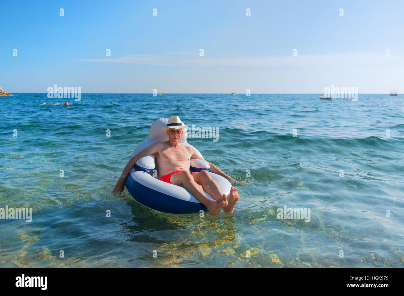Senior uomo in vacanza galleggiante sulla sedia in mare Foto Stock