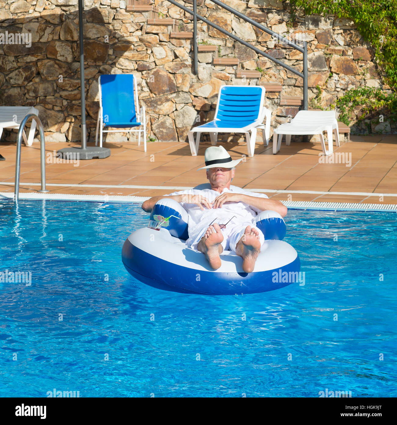 Uomo ricco rilassante in piscina Foto Stock
