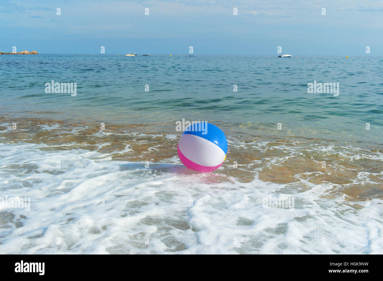 Gonfiabili colorati palla spiaggia a giocare con il surf e il mare Foto Stock