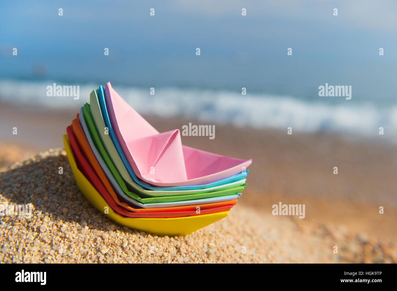 Carta impilata barche alla spiaggia a giocare con Foto Stock