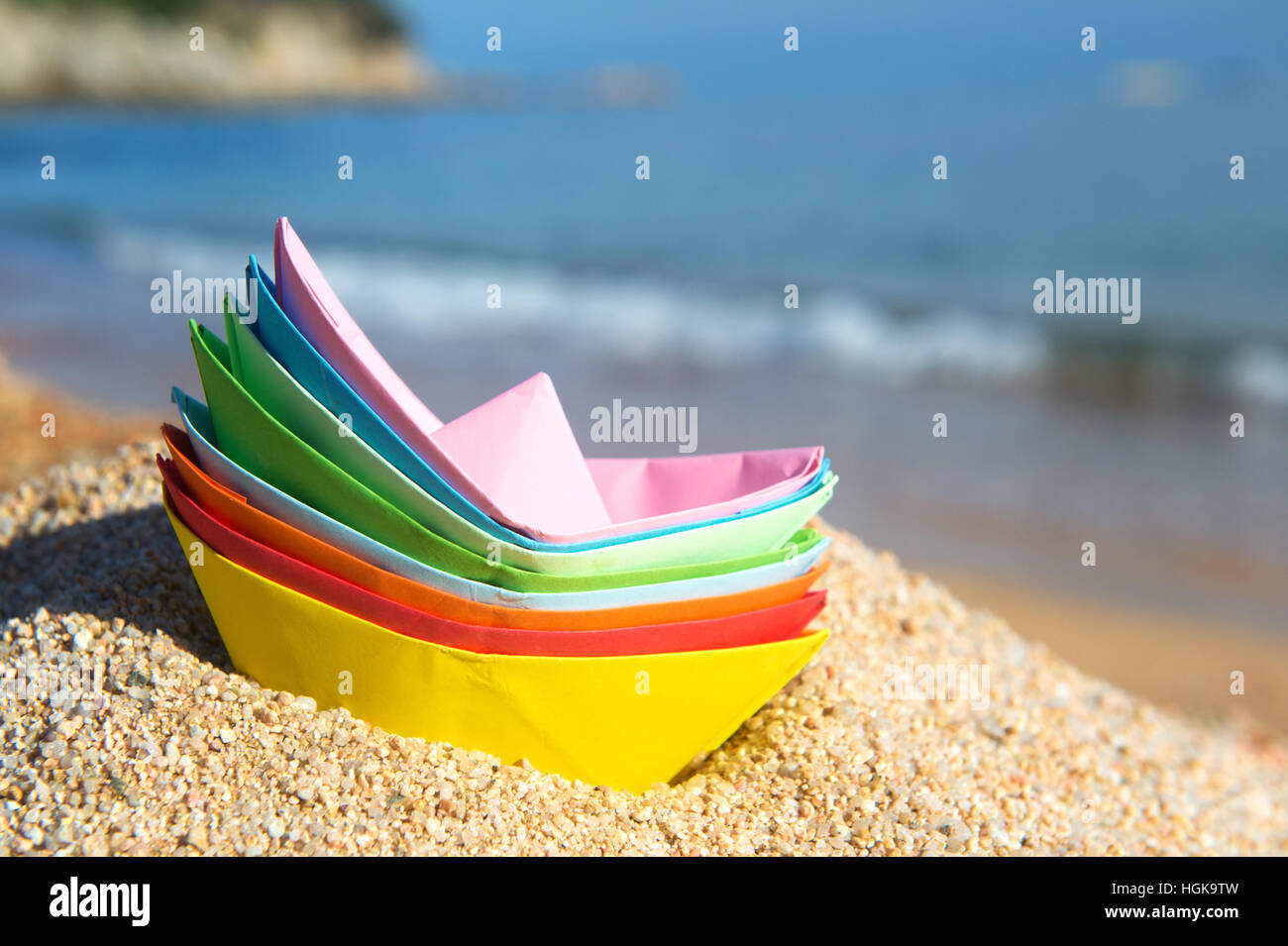 Carta impilata barche alla spiaggia a giocare con Foto Stock