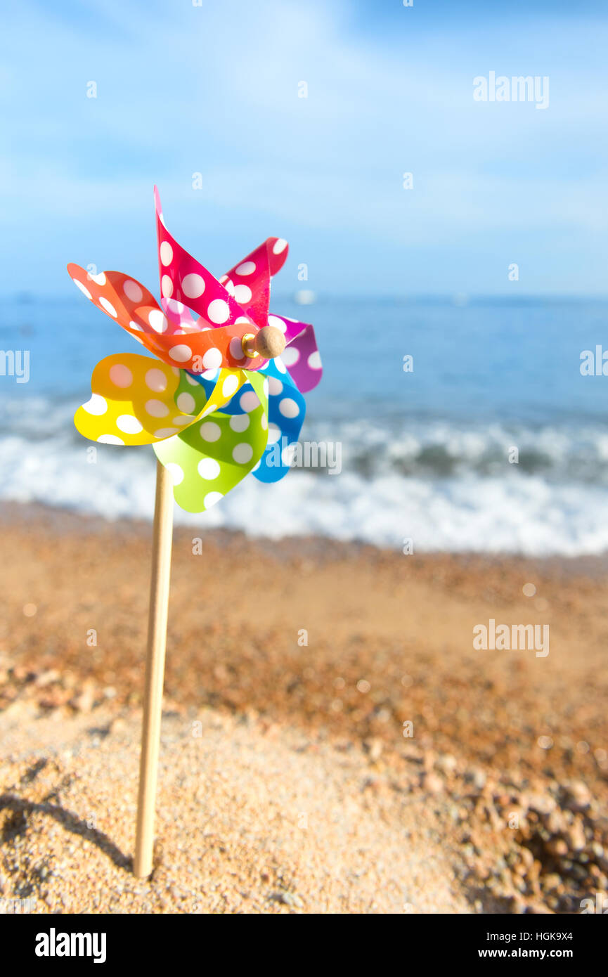 Giocattolo colorato turbina eolica in spiaggia Foto Stock