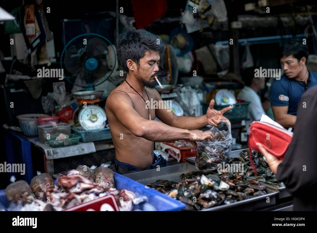 fumare sigaretta, serve cibo. Il venditore di cibo thailandese che fuma una sigaretta mentre serve un cliente. Thailandia, S. E. Asia Foto Stock
