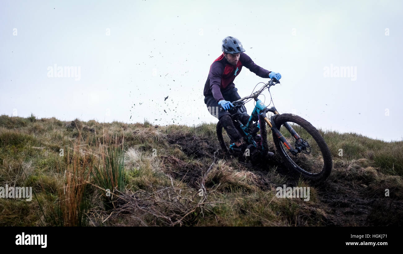 Un mountain biker, cavalca un sentiero su una collina gallese nel Regno Unito per la sua moderna full suspension bike. Foto Stock