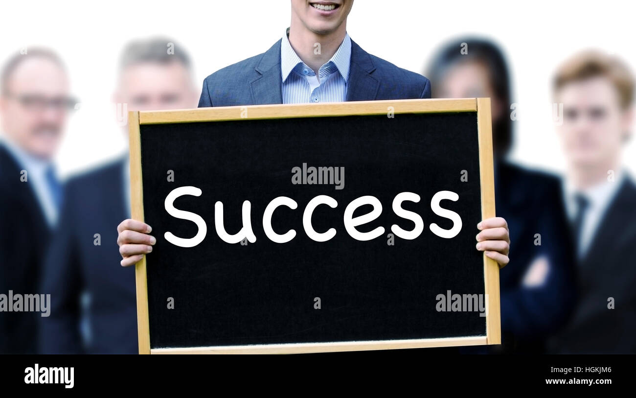 Giovane imprenditore tenendo un cartello con scritto la parola il successo e il gruppo di persone dietro di lui Foto Stock