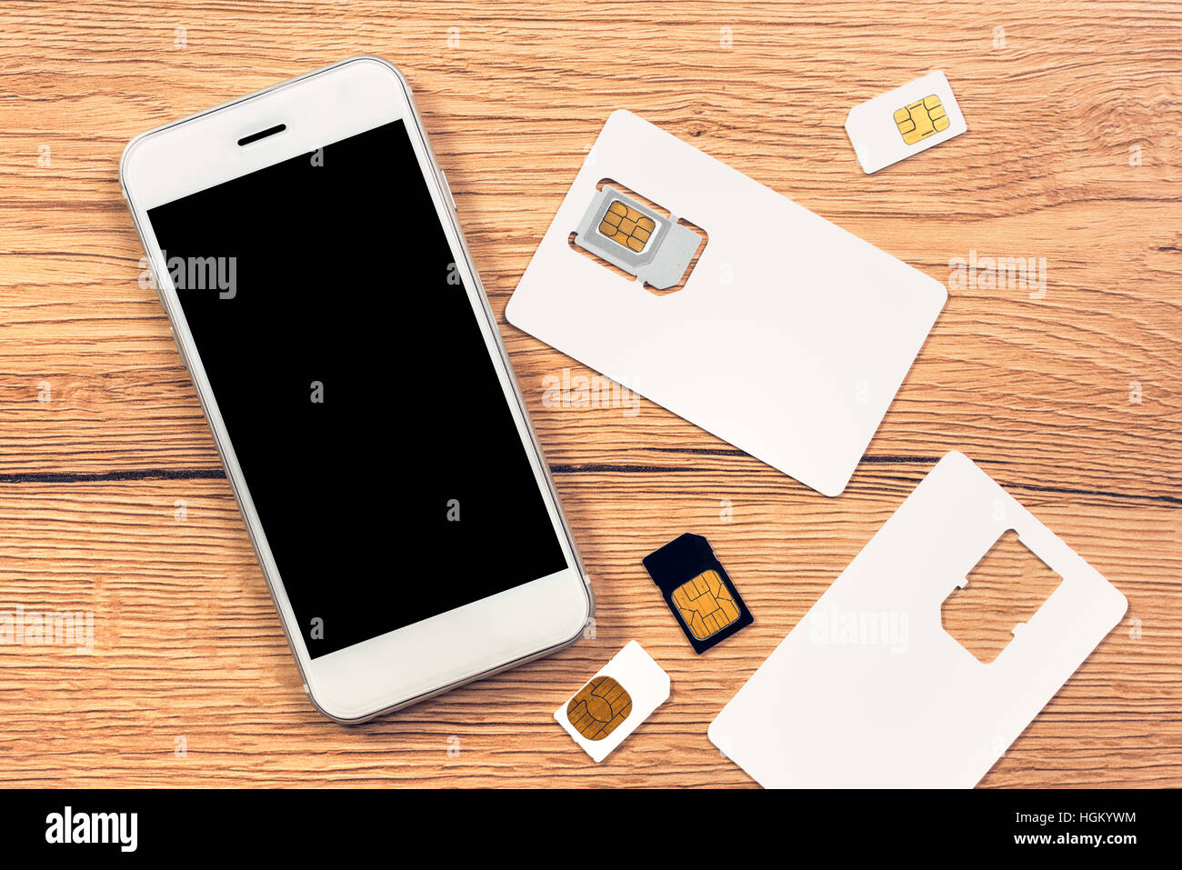 Smartphone con schermo vuoto e le schede SIM sul tavolo, vista dall'alto Foto Stock