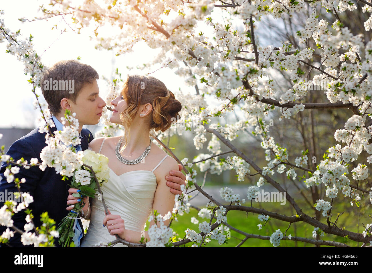 Sposa e lo sposo alle nozze kiss nella molla a piedi Park Foto Stock