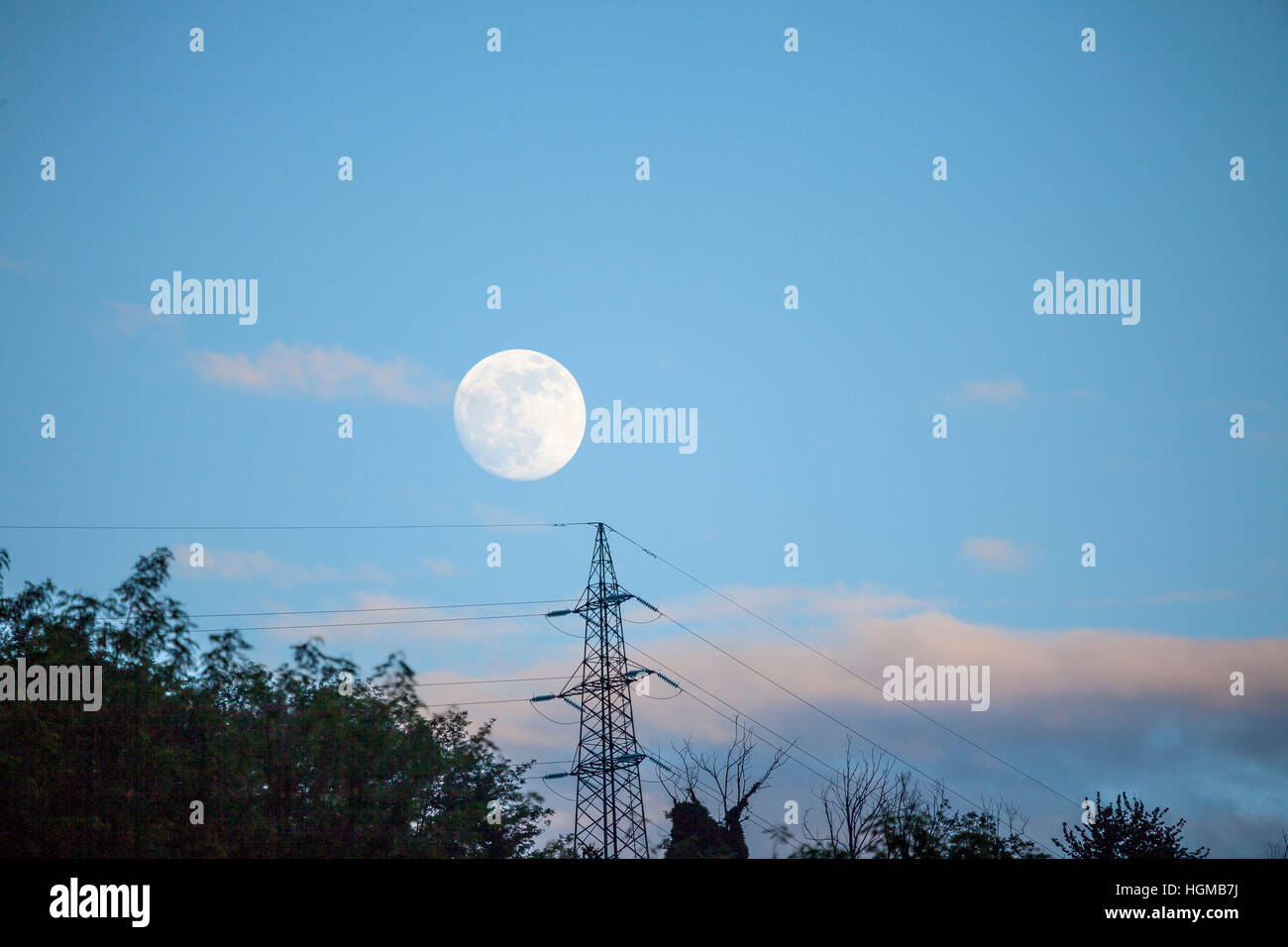 Luna piena sopra i cavi elettrici Foto Stock