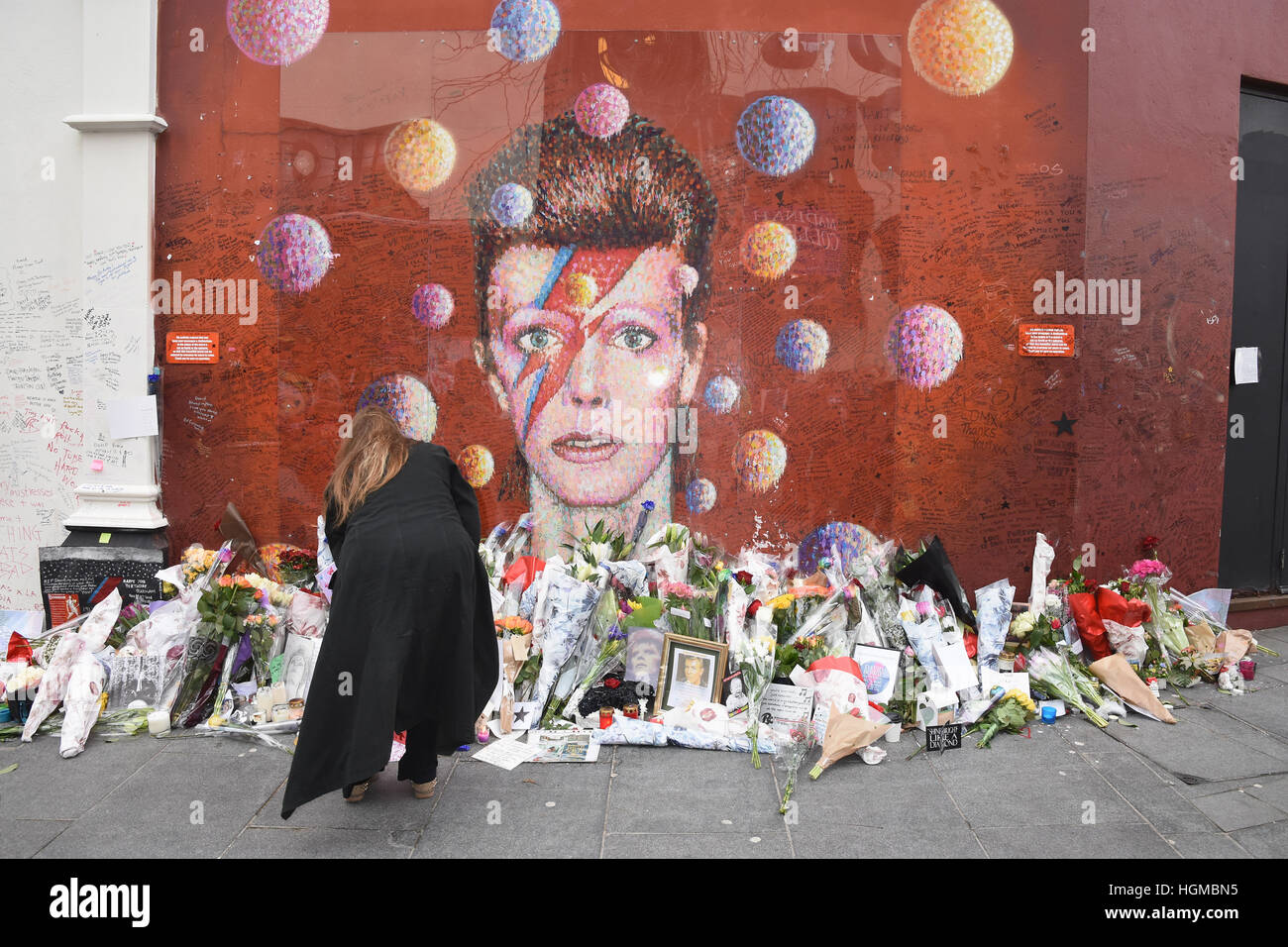 I fan hanno lasciato tributi floreali al Murale di David Bowie a Brixton nel primo anniversario della sua morte, Brixton, London.UK Foto Stock