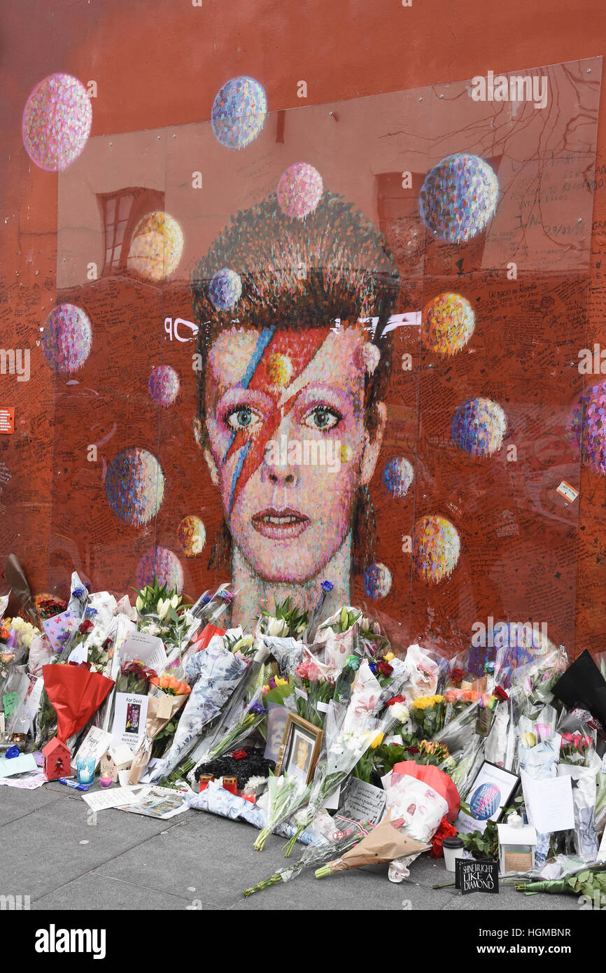 Omaggi floreali lasciati dai fan di David Bowie al murale di Brixton nel primo anniversario della sua morte ,London.UK Foto Stock