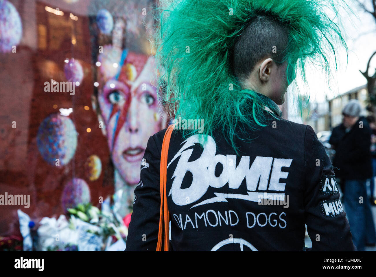 Londra, Regno Unito. Il 10 gennaio, 2017. Una ragazza con una verde mohicano haircut paga il tributo di David Bowie a fronte di un murale di Brixton nel primo anniversario della sua morte. Credito: Mark Kerrison/Alamy Live News Foto Stock