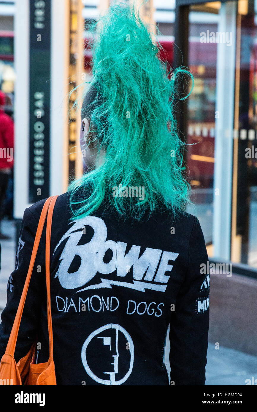 Londra, Regno Unito. Il 10 gennaio, 2017. Una ragazza con una verde mohicano haircut paga il tributo di David Bowie a fronte di un murale di Brixton nel primo anniversario della sua morte. Credito: Mark Kerrison/Alamy Live News Foto Stock