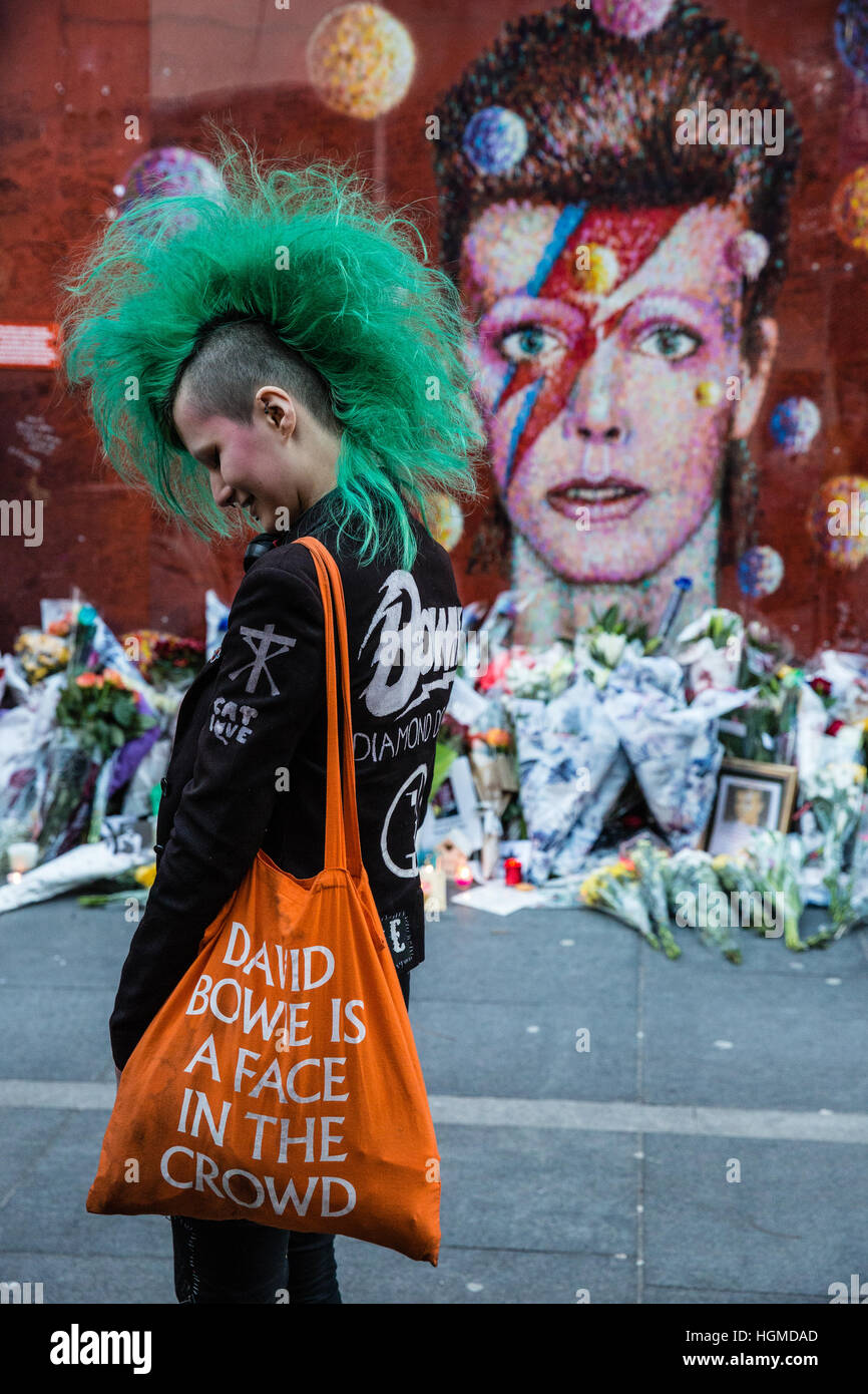 Londra, Regno Unito. Il 10 gennaio, 2017. Una ragazza con una verde mohicano haircut paga il tributo di David Bowie a fronte di un murale di Brixton nel primo anniversario della sua morte. Credito: Mark Kerrison/Alamy Live News Foto Stock