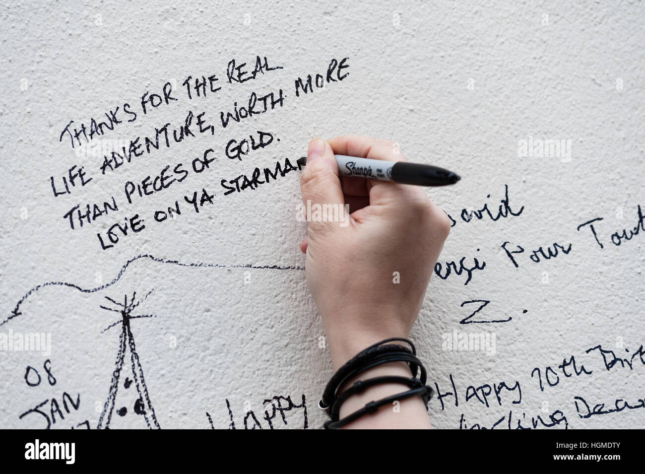 Londra, Regno Unito. Il 10 gennaio 2017. Tifosi si riuniscono da murale di David Bowie in artista il luogo di nascita di Brixton per commemorare il primo anniversario della morte del musicista. Brixton il Murale che raffigura Bowie faccia da Aladdin sane della copertina dell'album è diventato il principale sito memoriale dopo la stella della morte il 10 gennaio 2016. Wiktor Szymanowicz/Alamy Live News Foto Stock