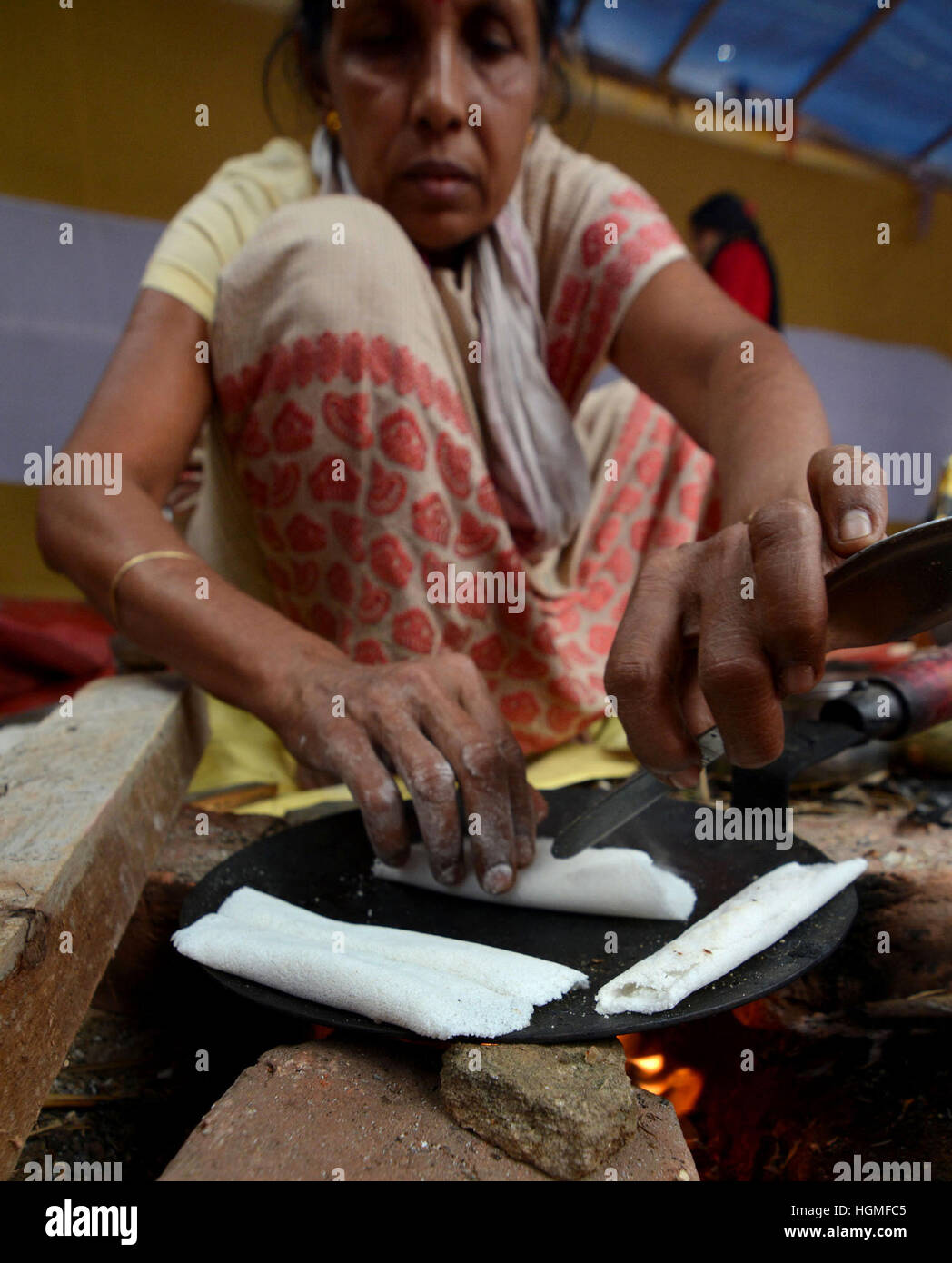 Guwahati (India). Il 10 gennaio, 2017. Una donna si prepara 'Pitha" (torta di riso), un piatto tradizionale alla vigilia di "Bhogali Bihu", una festa che segna la fine dell'Inverno stagione di raccolto a Guwahati, Nord Est India membro © Stringer/Xinhua/Alamy Live News Foto Stock