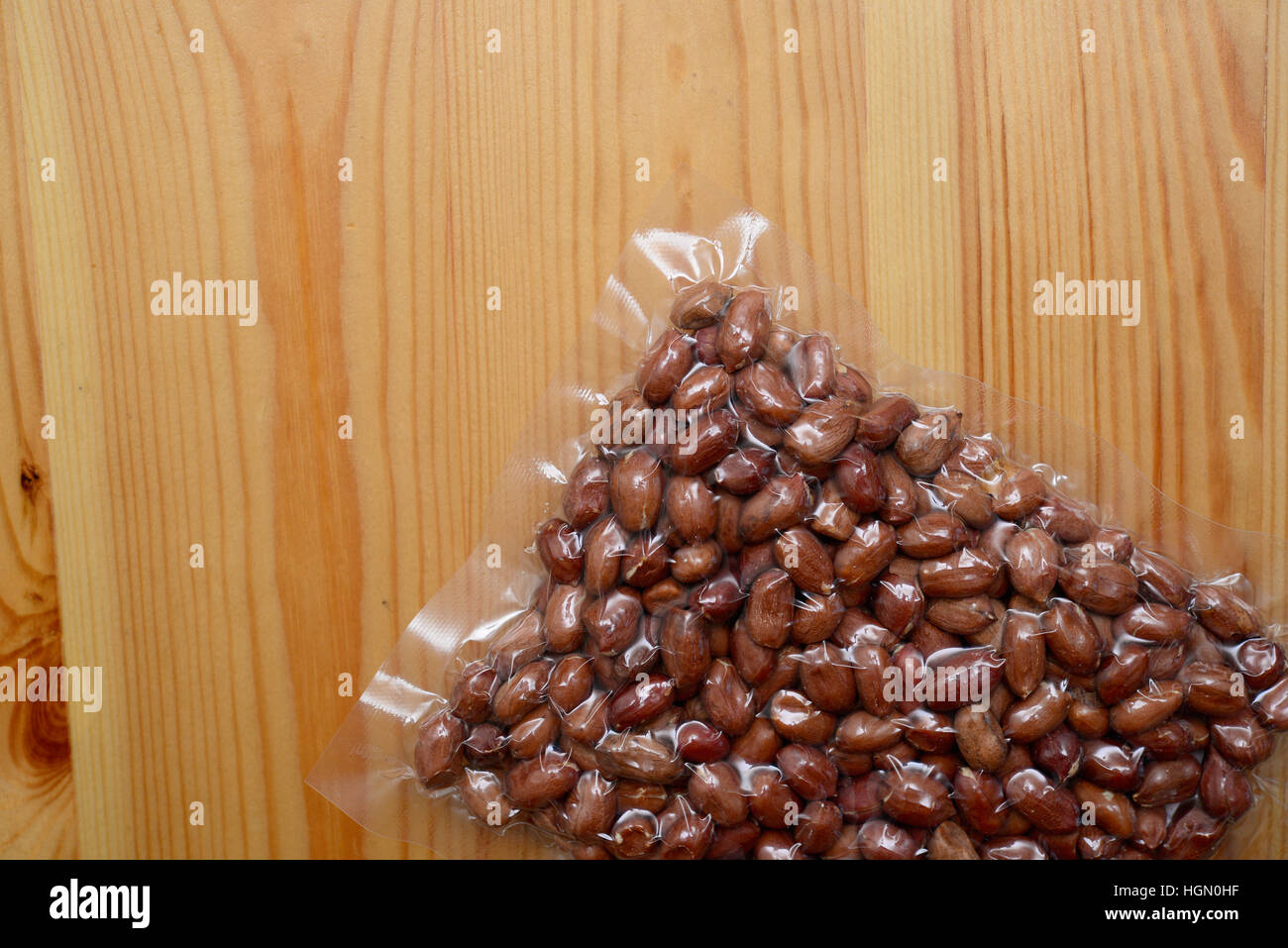 Imballaggio arachidi sullo sfondo di legno Foto Stock