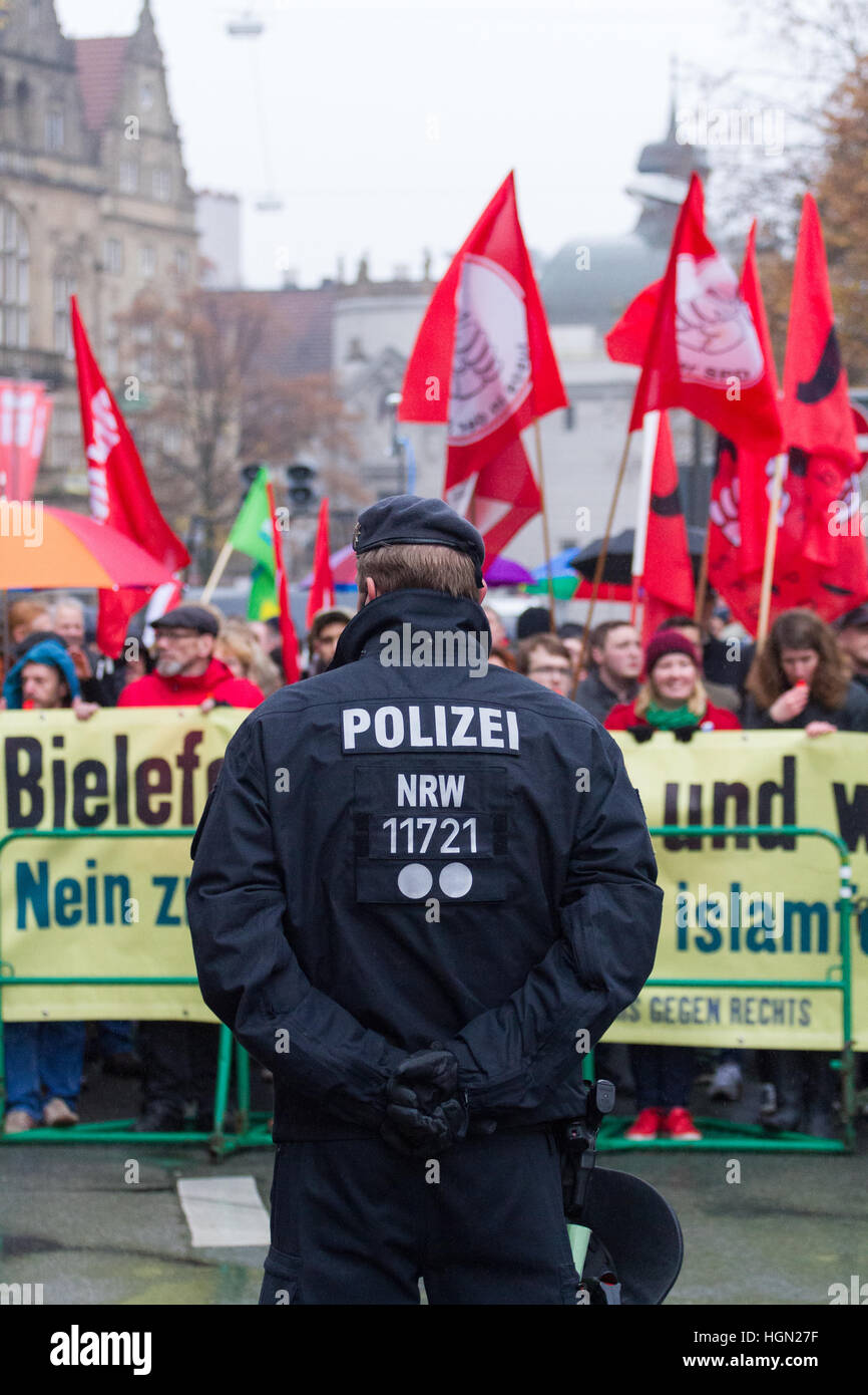 In Germania un funzionario di polizia si erge davanti a una folla di manifestanti Foto Stock