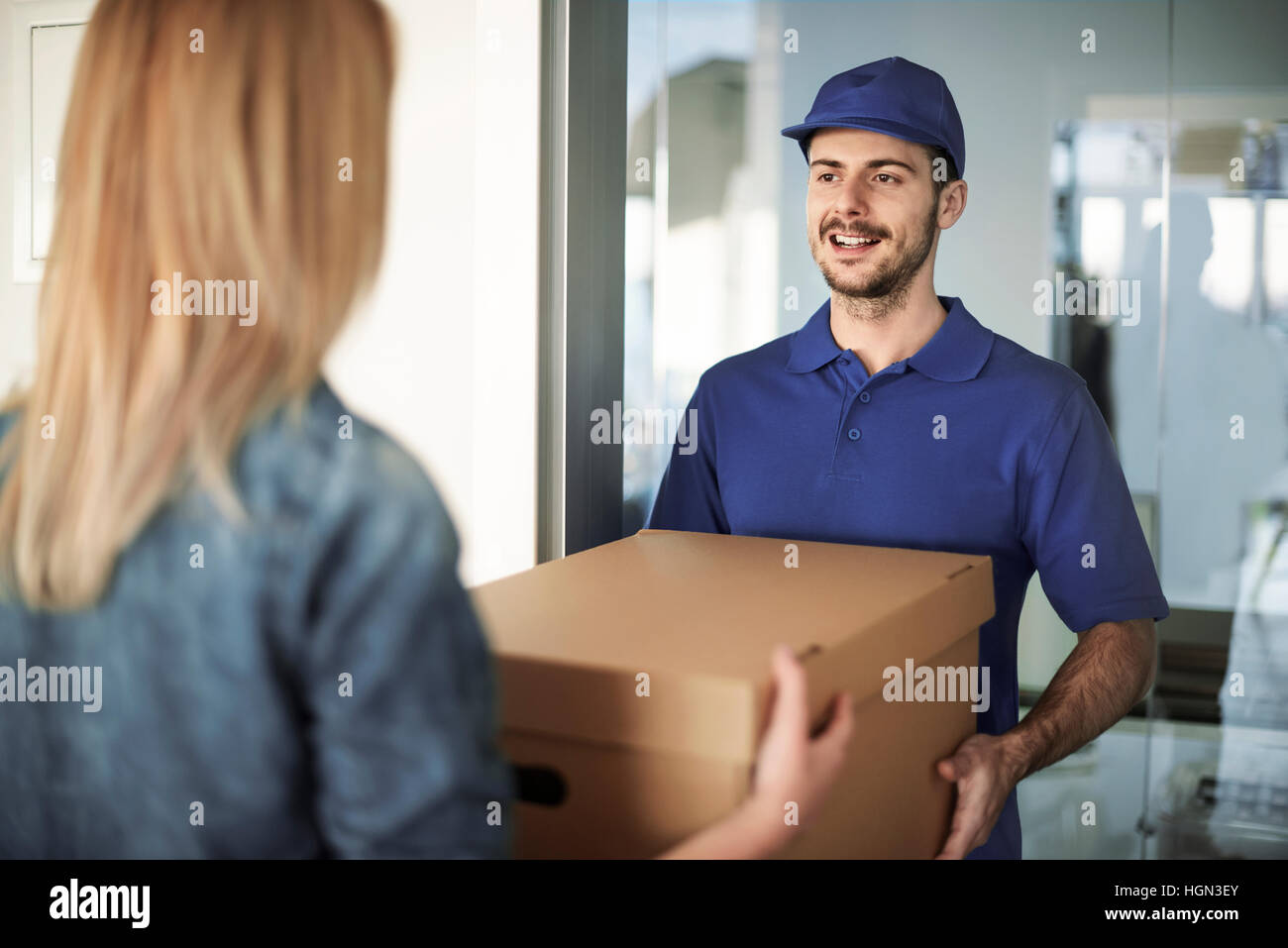 Uomo di consegna Consegna casella per donna Foto Stock