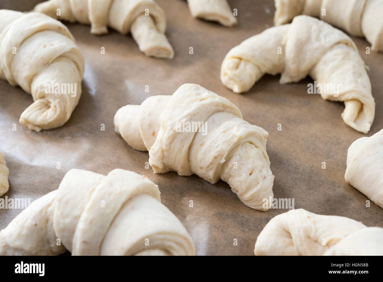 Croissant fatti in casa a forma di pasta e salita prima di essere cucinati Foto Stock
