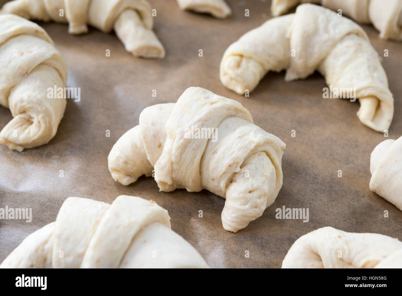 Croissant fatti in casa a forma di pasta e salita prima di essere cucinati Foto Stock