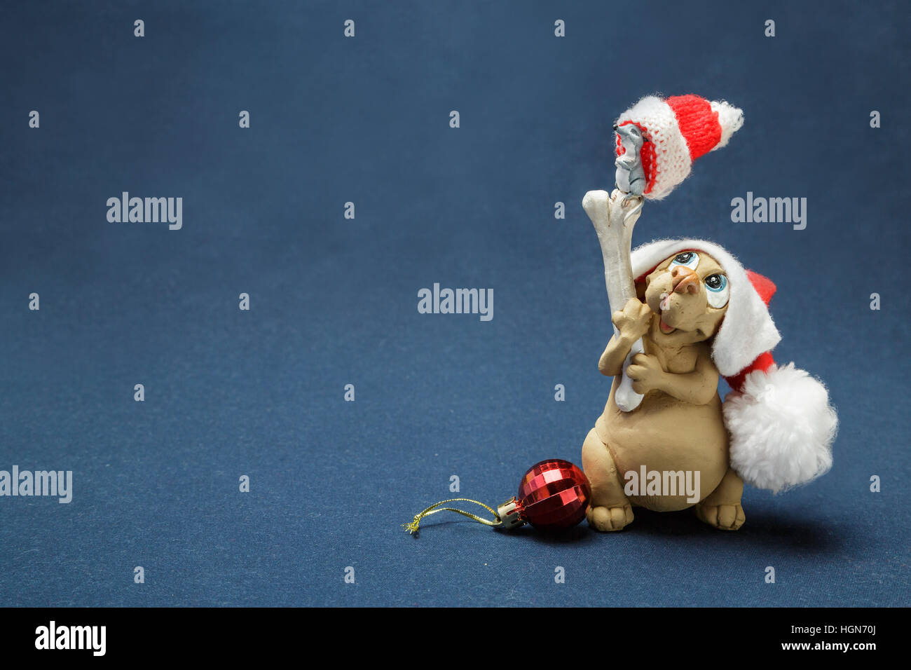 Il cane possiede un osso su cui il mouse e sia in caps e vicino a una sfera di vetro Foto Stock