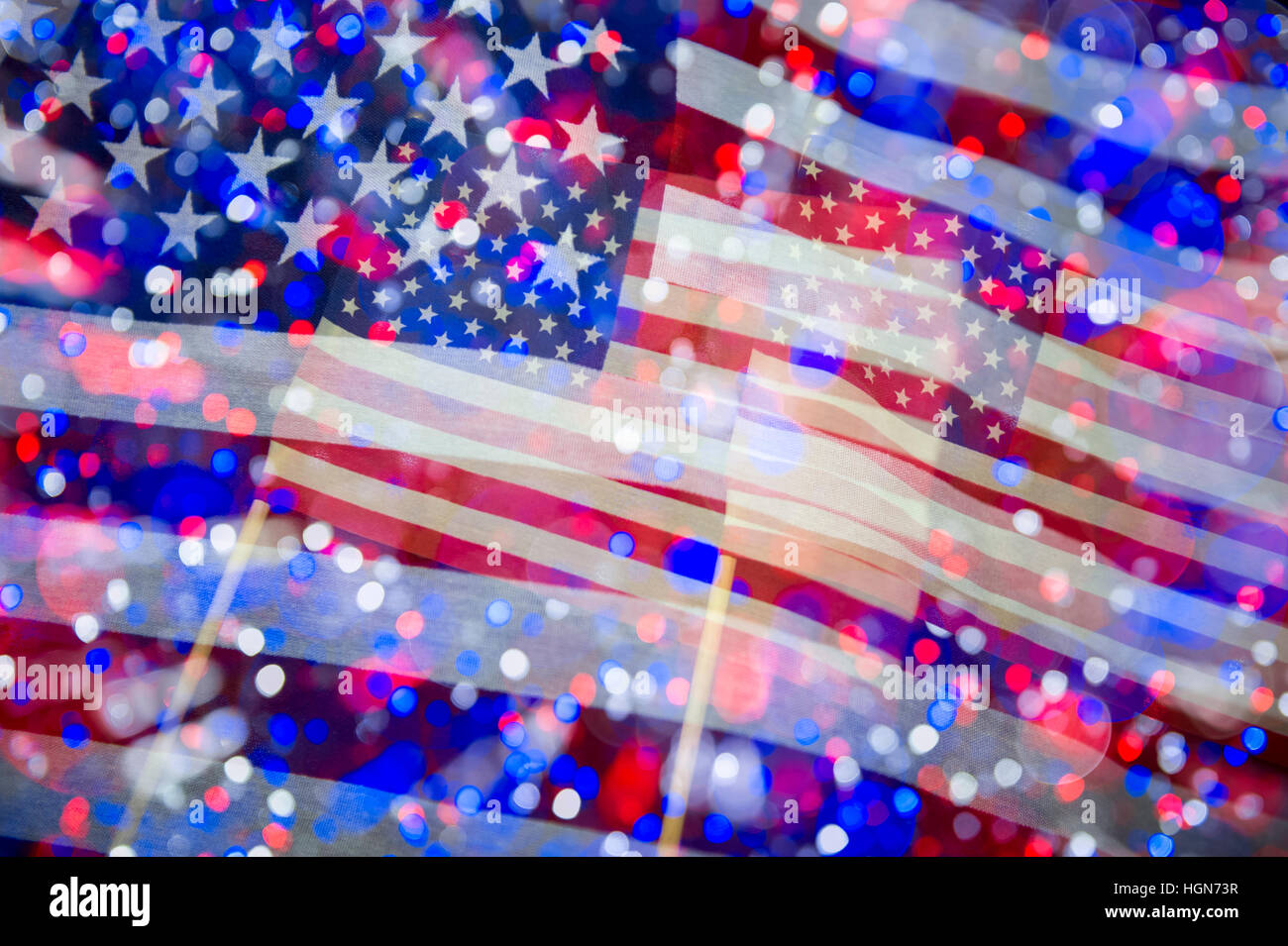American bandiere sventolano in motion blur contro un sfondo celebrativo di rosso, bianco e luci blu Foto Stock