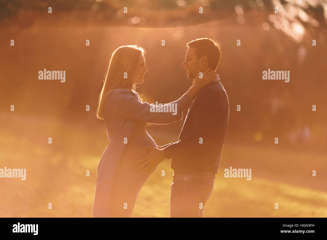 La donna incinta e il suo amorevole che pongono l uomo al parco di autunno Foto Stock