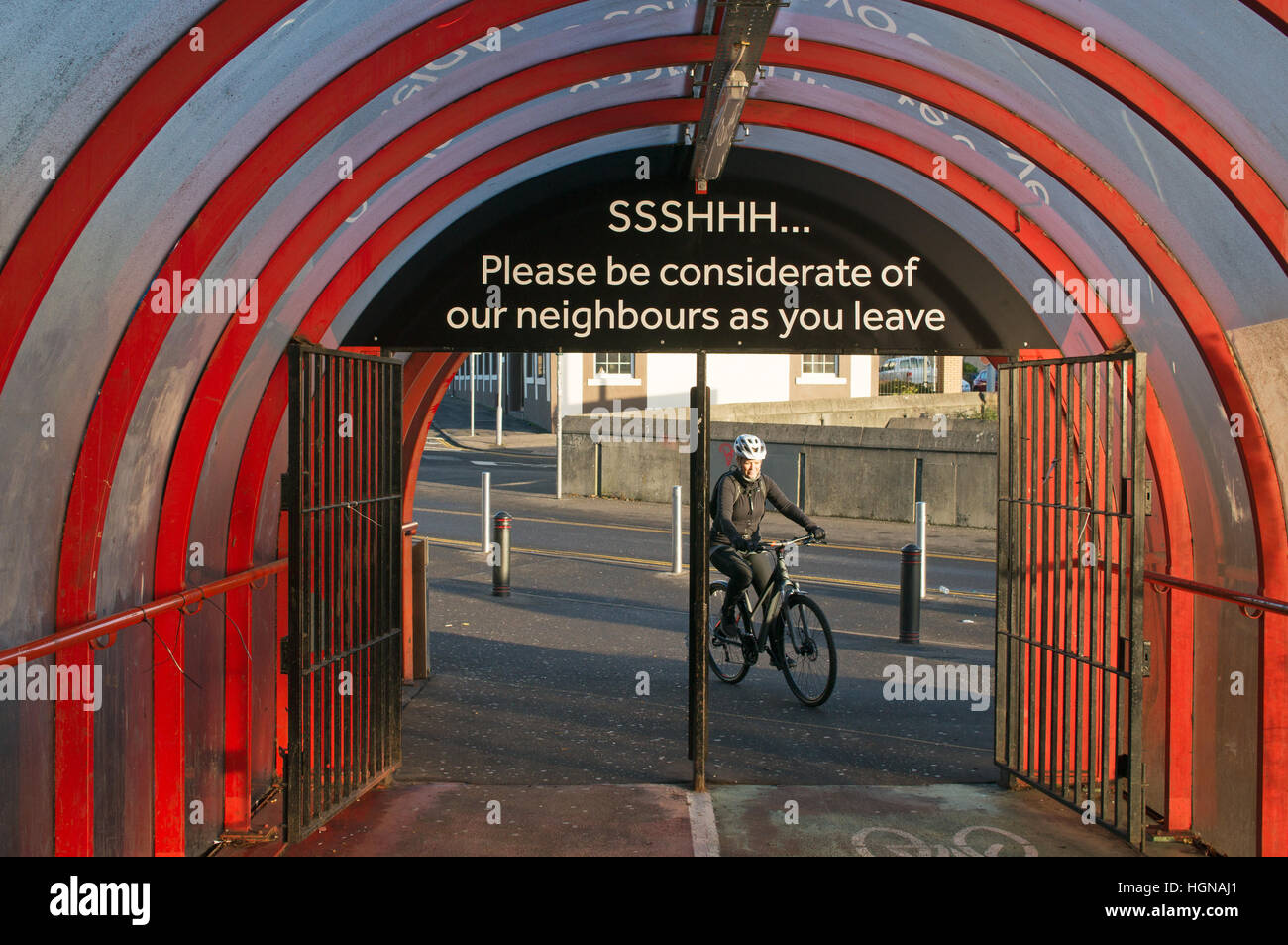 Una femmina di ciclista avvicinandosi il percorso coperto dal SSE idro attraverso il Clyde Expressway, Glasgow, Scotland, Regno Unito Foto Stock