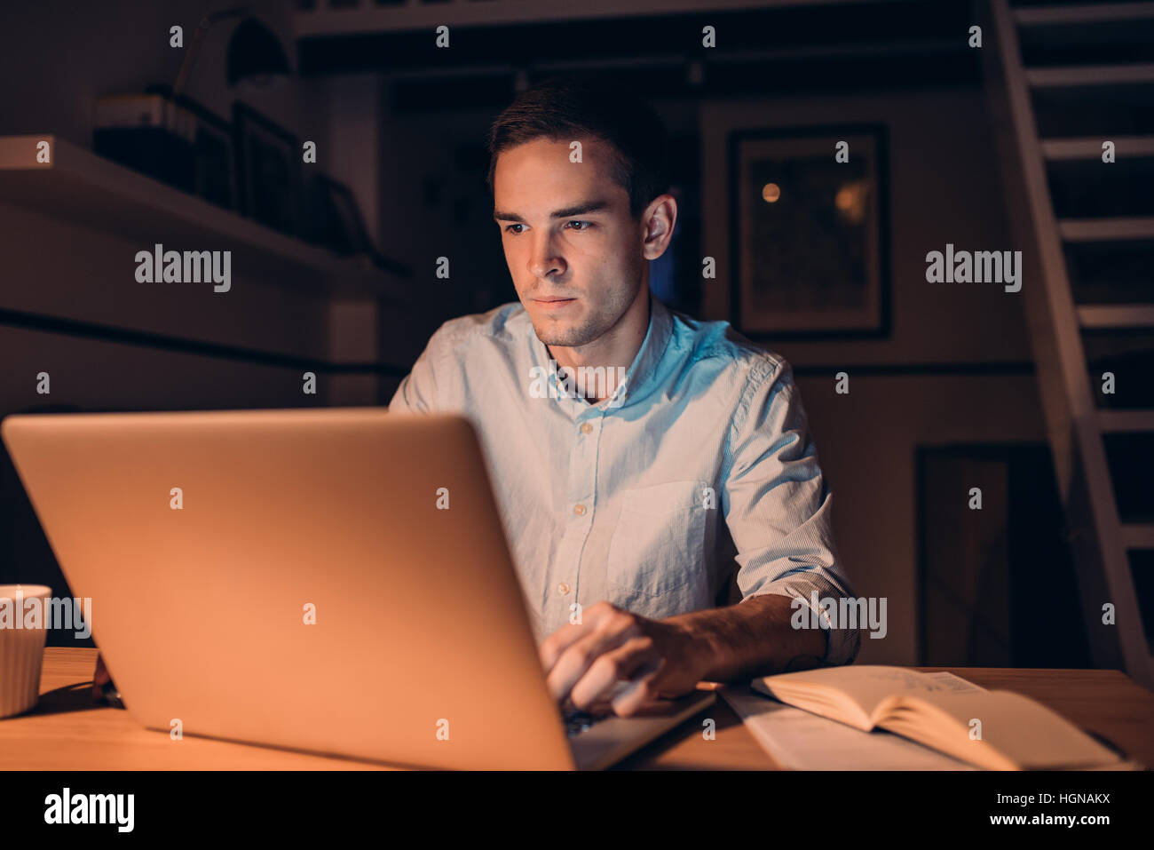 Giovane imprenditore lavora su un laptop a tarda notte Foto Stock