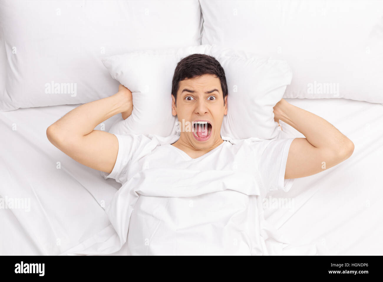 Uomo disteso nel letto e urlando Foto Stock