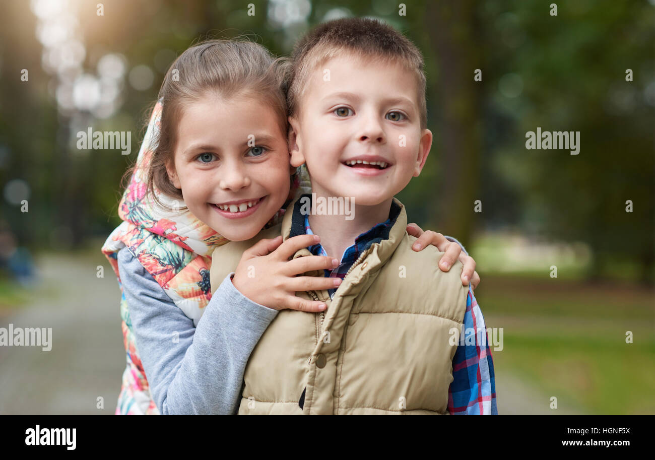 Sorridente piccolo fratello e sorella al di fuori Foto Stock