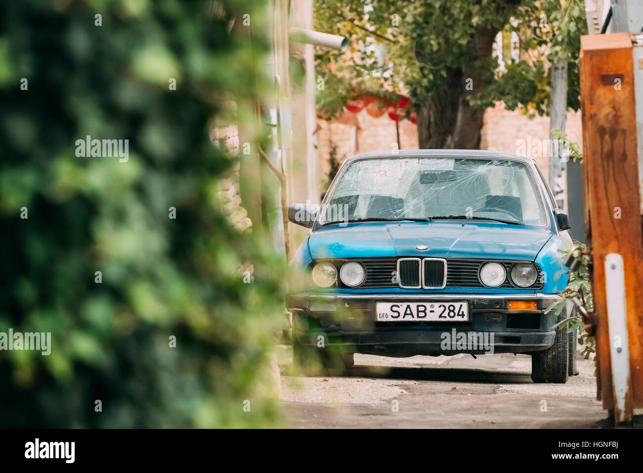 Tbilisi, Georgia - 21 Ottobre 2016: il vecchio danneggiato rusty berlina BMW Serie 3 (E30) Il parcheggio sulla strada. La BMW E30 è un entry-level di auto di lusso che Foto Stock