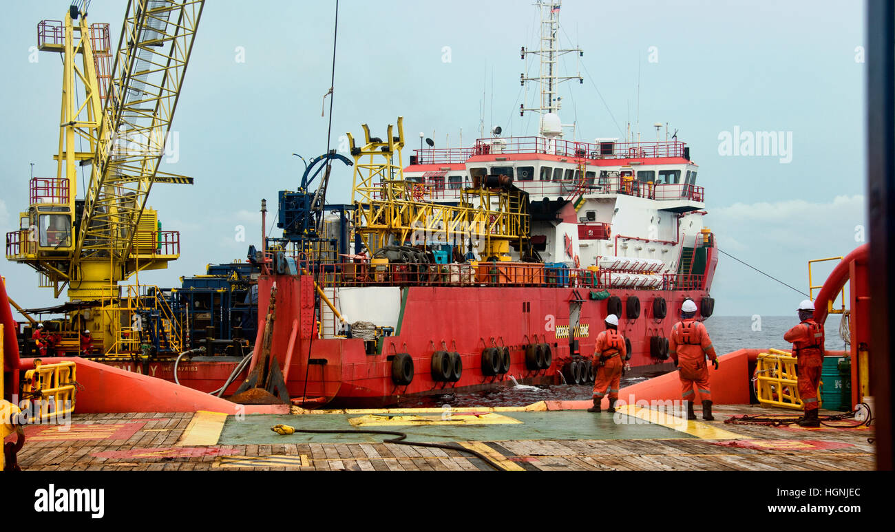 Equipaggio marino lavorano sul ponte durante il trasferimento sotto forma di ancoraggio di altre navi durante la giornata di sole Foto Stock