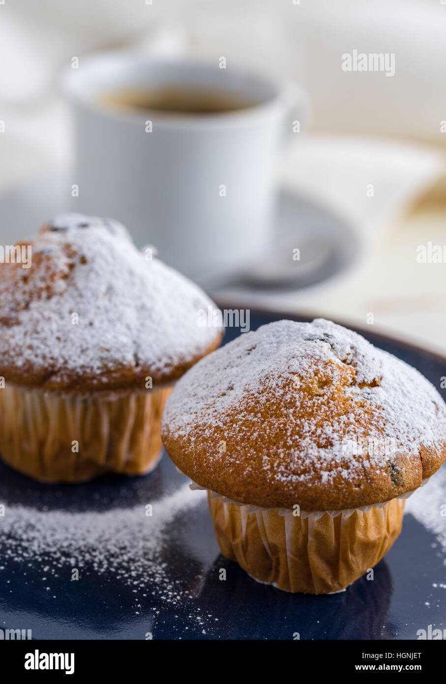 La prima colazione con i muffin cosparsa di zucchero in polvere e il caffè. Foto Stock